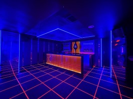 Illuminated bar with mirrored walls and graphic floor lighting at COVA Club Paris