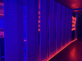 Blue and red architectural lighting along the mirrored corridor at COVA Club Paris