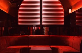 Red illuminated lounge seating beneath the Palais-Royal at Lowkey Paris